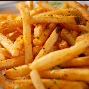 Cajun fries with savory seasoning and herbs are served on a plate.