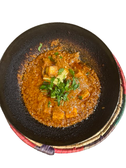 Paneer Karahi served in a karahi pot with garnished chilli and herbs