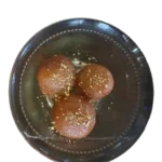 3 pieces in gulab jamun with dry fruit mixture in a bowl