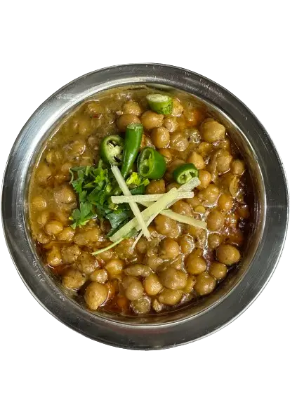 Spicy, flavorful Lahori chanay served in a large bowl, topped with chilies, ginger, and coriander.