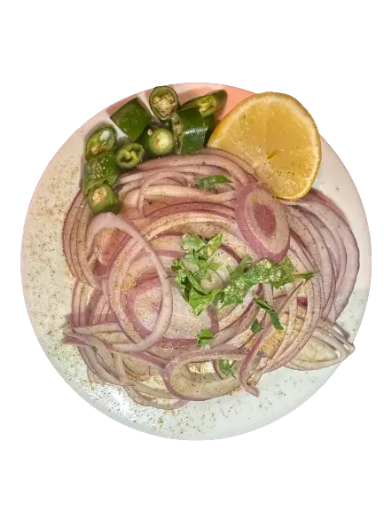 A plate of onion salad with chillies and lemon