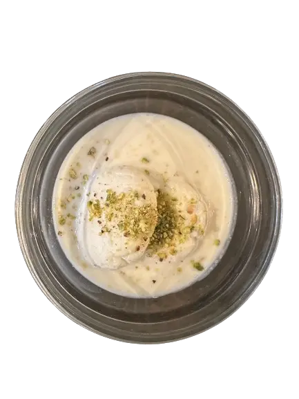 A ras malai on silver plate with pistachio topping