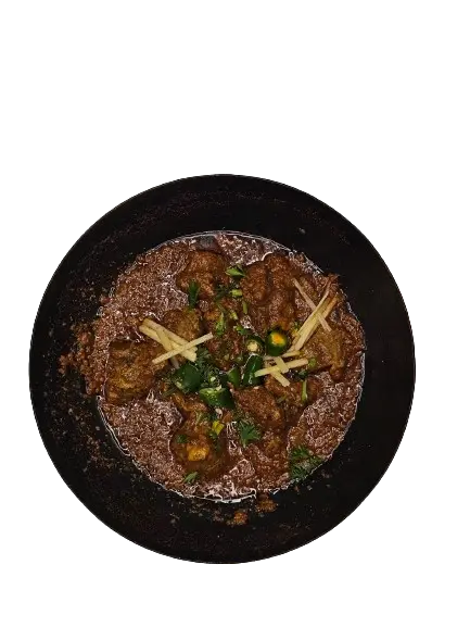 Chicken Peshawari Karahi served in a hot pan topped with chili slices and freshly chopped ginger