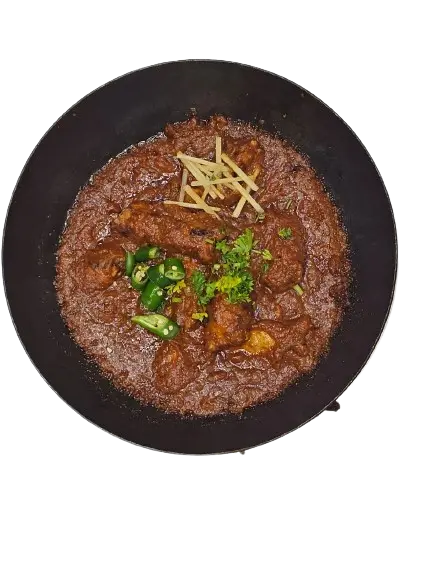 A full kabab karahi on karahi with a topping of garlic and chili